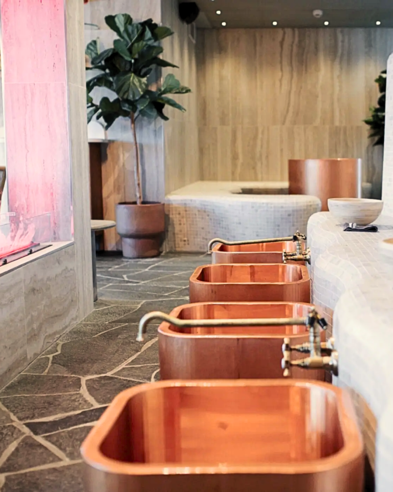 Spa med kopparbadkar och stengolv.